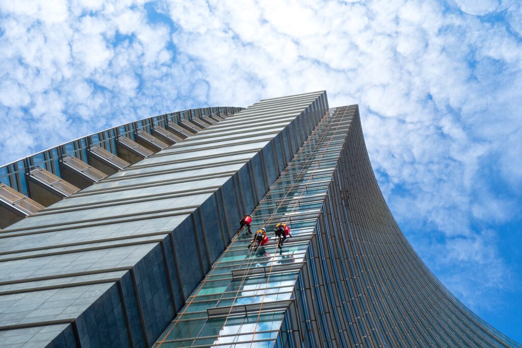 Group of Alpinists in service for windows cleaning of skyscraper
