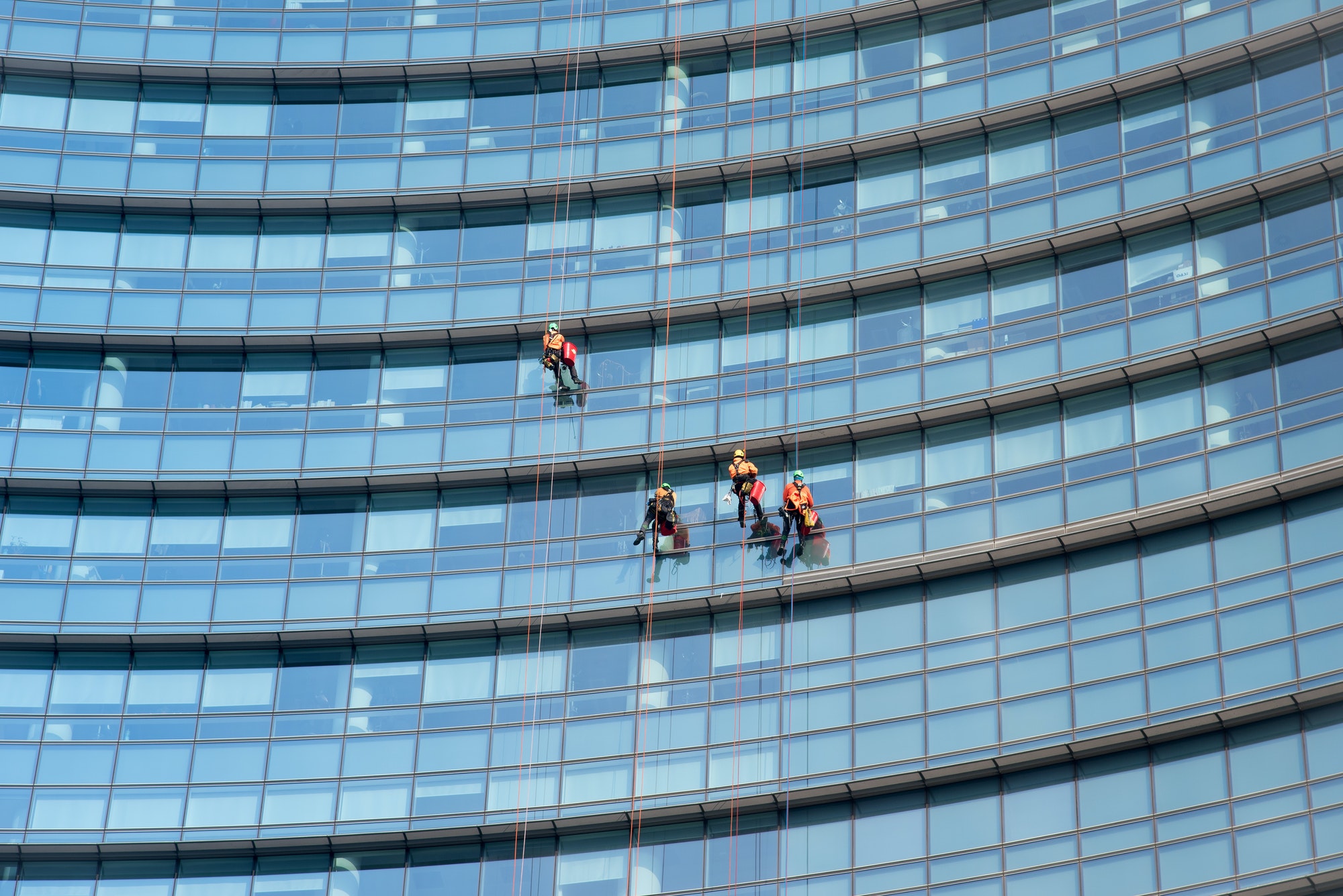 Window cleaners suspended on side of a skyscraper